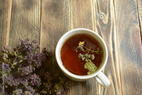 Cup of tea and oregano on a wooden background herbal tea