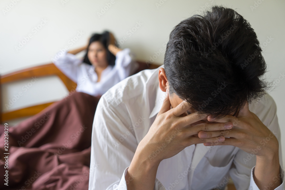 Young worried man on bed. Unhappy couple having problem in bedroom. Young worried man on bed. Unhappy couple having problem in bedroom.