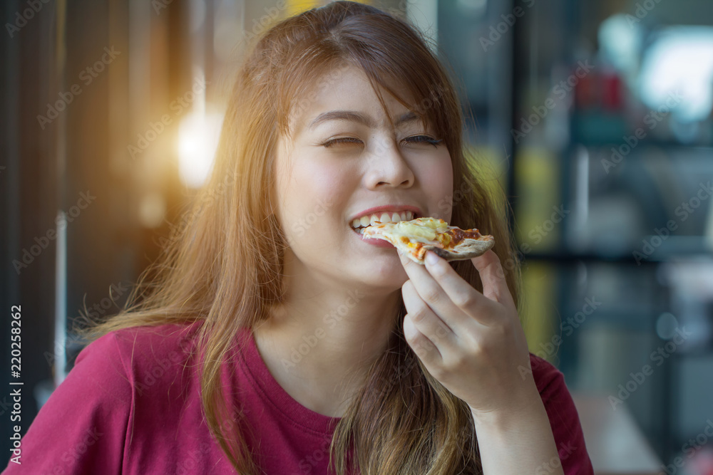 Woman eating pizza at restaurant.