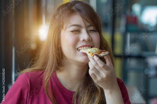 Woman eating pizza at restaurant.