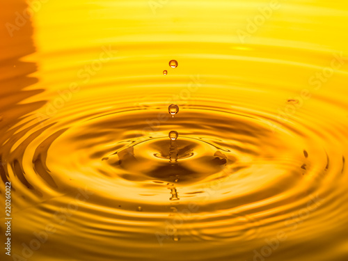 close up of a drop oil on a yellow background