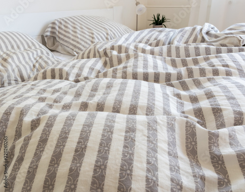 striped bedclothes on bed, and untouched duvets and pillows in the morning, long night sleep