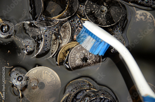 Black Danisk Krone coins being washed, suggesting the term 