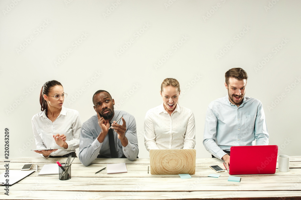 Young african and caucasian men and women sitting at office and working on laptops. The business, emotions, team, teamwork, workplace, leadership, meeting concept. different emotions of colleagues Young african and caucasian men and women sitting at office and working on laptops. The business, emotions, team, teamwork, workplace, leadership, meeting concept. different emotions of colleagues