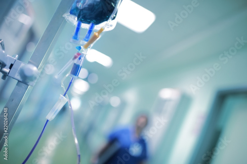 Foto Intravenous drip with blue liquid ready to use on the background of walking arou