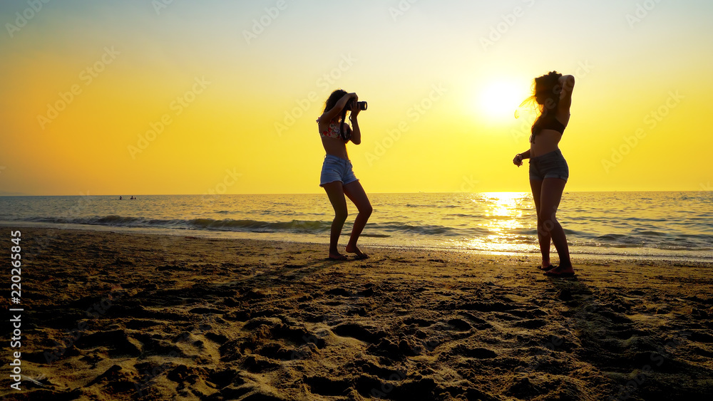 Fashion model girl posing on beach sunset at photography session