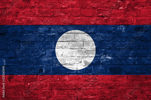 Flag of Laos over an old brick wall background, surface