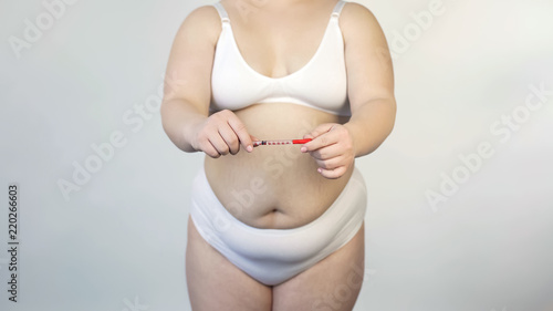 Obesity consequences, plump woman holding insulin syringe, diabetes mellitus