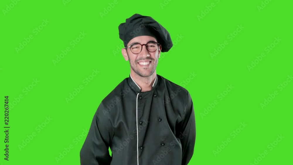 Happy young chef posing against green background Happy young chef posing against green background