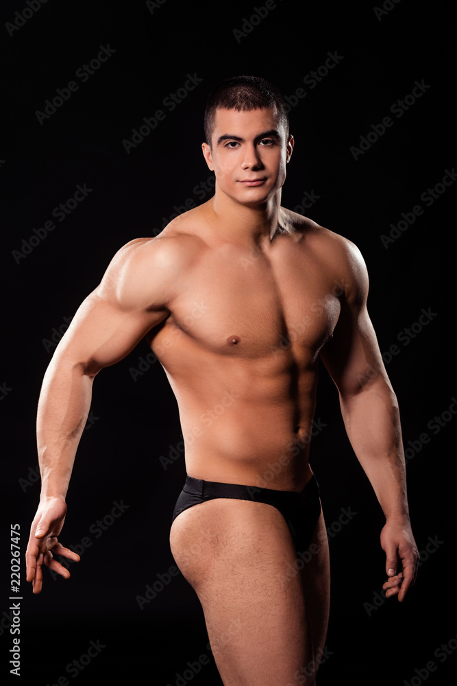 Young shirtless bodybuilder posing.