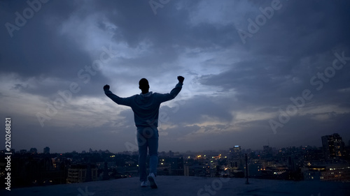 Winner male silhouette and night cityscape on background, achieving goals