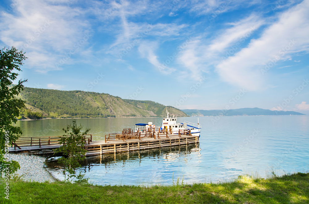 Paysage of a pier with boatsa blue water of lake and sky. Paysage of a pier with boatsa blue water of lake and sky.
