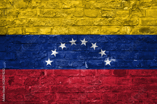 Flag of Venezuela over an old brick wall background, surface