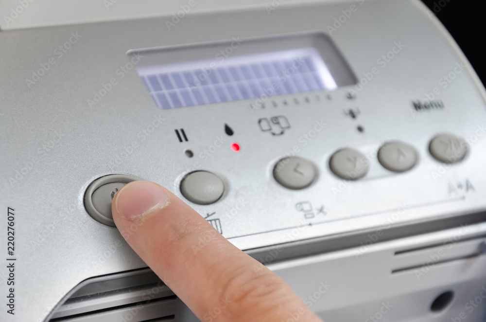 One finger pressing a print button on large printer ploter. Injet printing concept. One finger pressing a print button on large printer ploter. Injet printing concept.
