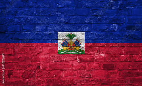 Flag of Haiti over an old brick wall background, surface