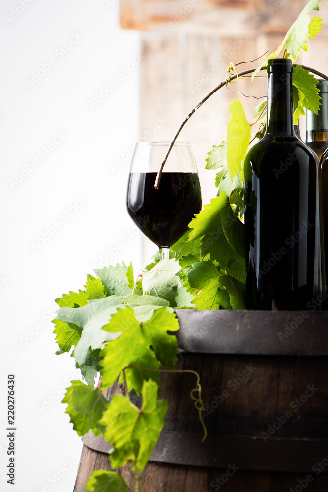 Glass of red wine on a barrel on white background