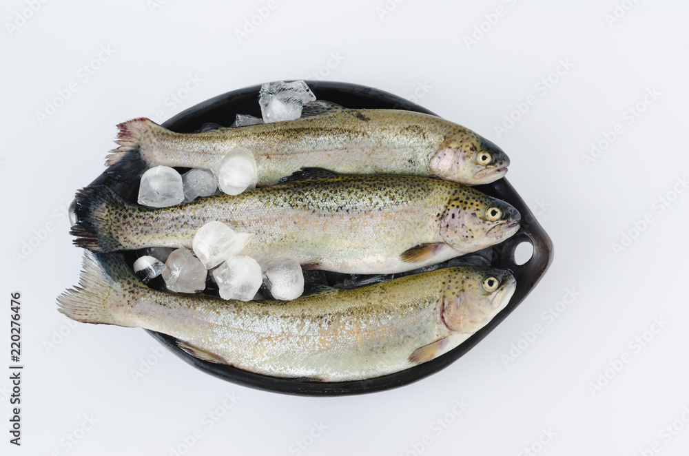 Trouts in black ceramic bowl on white background. Trouts in black ceramic bowl on white background.