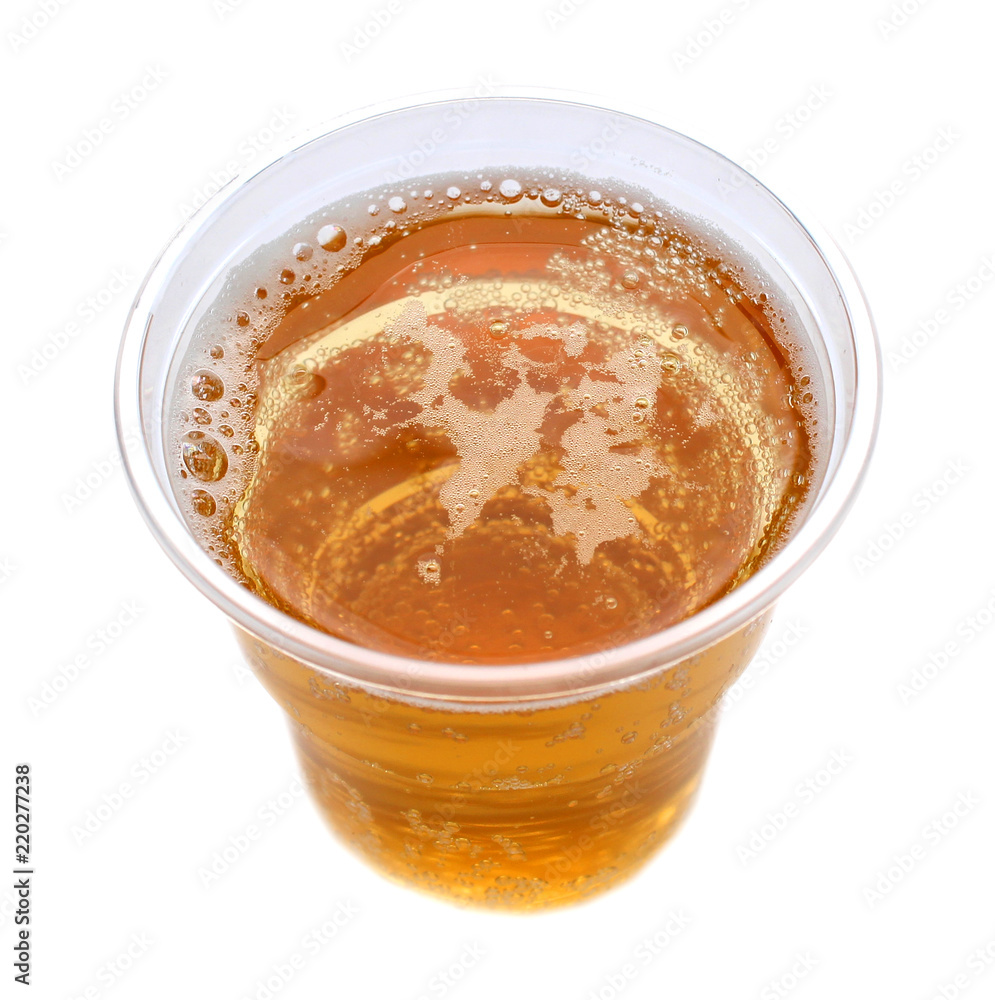 Plastic glass with a sparkling yellow drink, white isolated Plastic glass with a sparkling yellow drink, white isolated