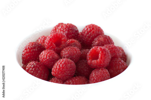A bowl of red raspberries on a white background