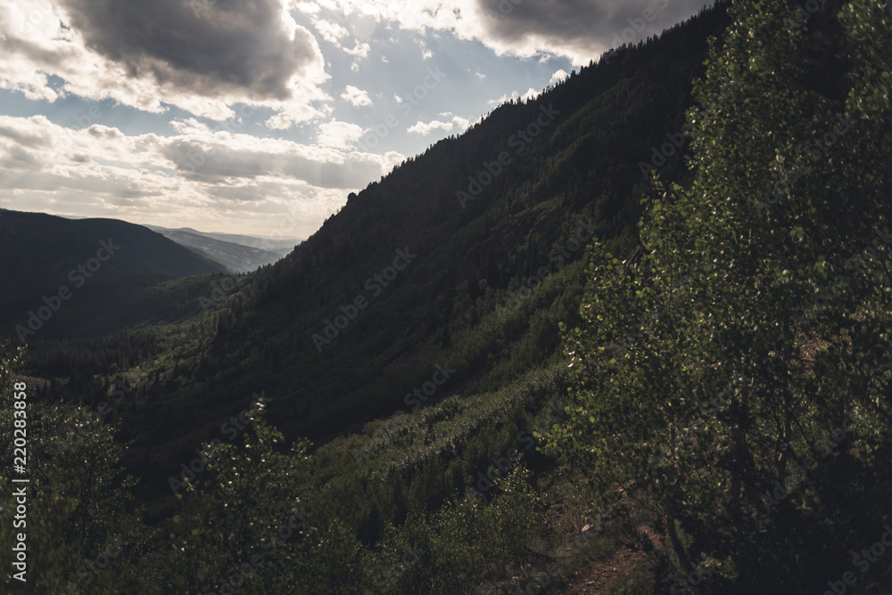 Landscape view with cloud shadows over a forested Valley near Vail, Colorado. 