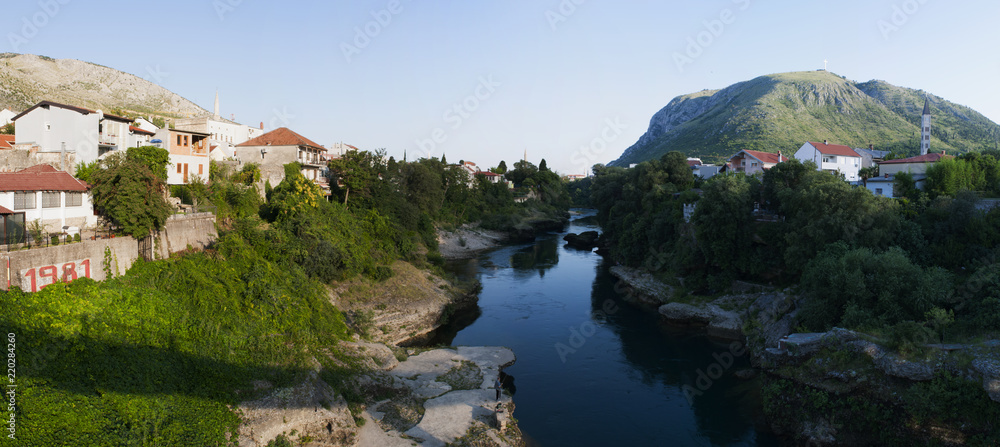 Bosnia: il fiume Narenta e lo skyline di Mostar, la città dello Stari Most (Ponte Vecchio) vista dal ponte Bunur, un ponte pedonale all'inizio della parte moderna della città