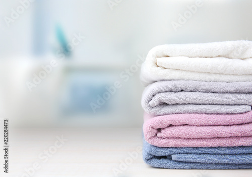 Colorful folded towels stack on table empty space. photo