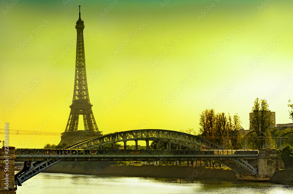 View of the Eiffel tower and Cygnes bridge over Seine river at sunrise, Paris