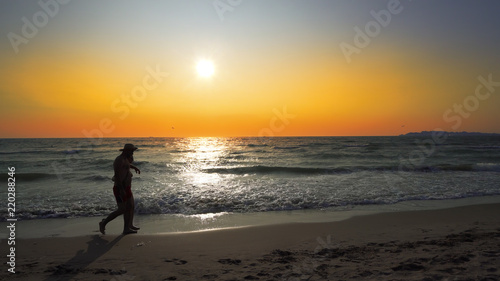 Loving Couple Holding Hands Beach Vacation Sunset - Young ethnic couple holding hands watching sunset on beach vacation