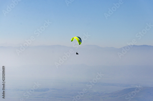 Paraglide silhouette above the misty Crimea valley