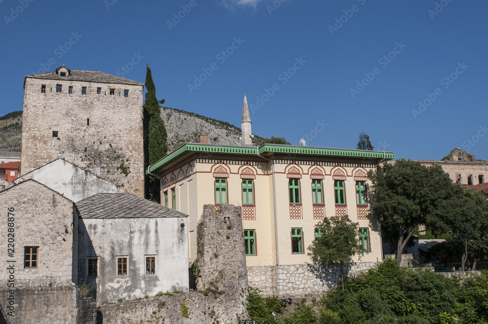 Bosnia: lo skyline di Mostar, la città vecchia sul fiume Narenta, con un palazzo esempio dell'architettura austro-ungarica costruito durante il periodo della dominazione austro-ungarica