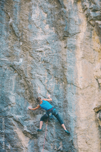 The climber is training to climb the rock.