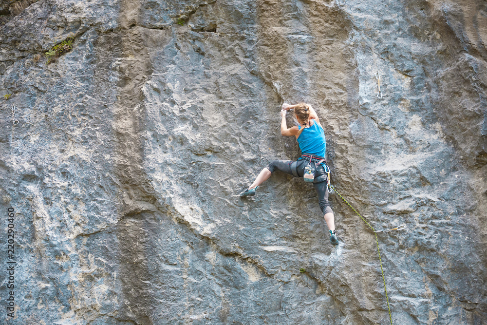 A woman climbs the rock.