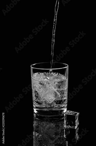 Carbonated water, which is poured into a glass with ice cubes.