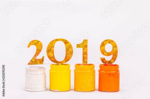 number of the year 2019 is made in gold color place on plastisol ink in white background photo