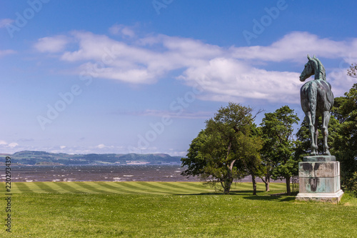 Edinburgh, Scotland, UK - June 14, 2012: Horse statue of King Tom looking at Firth of Forth on green lawn under blue sky at Dalmeny House. © Klodien