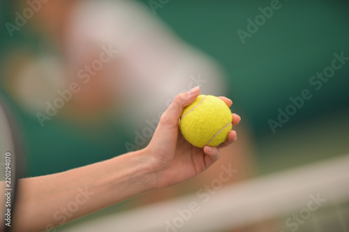 woman giving tennis ball in hand to you for play © auremar