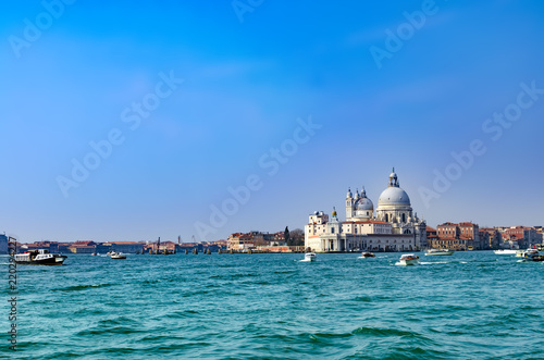 Beautiful view of traffic on famous Canal Grande with Basilica di Santa Maria della Salute in Venice, Italy