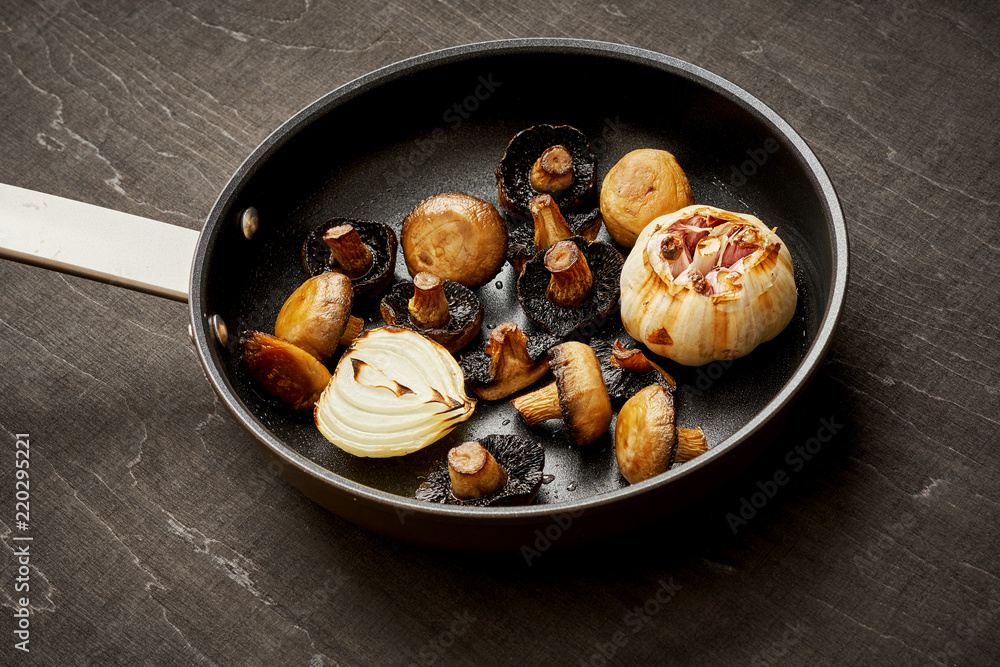 delicious fried mushrooms on a hot pan on an old wooden black table delicious fried mushrooms on a hot pan on an old wooden black table
