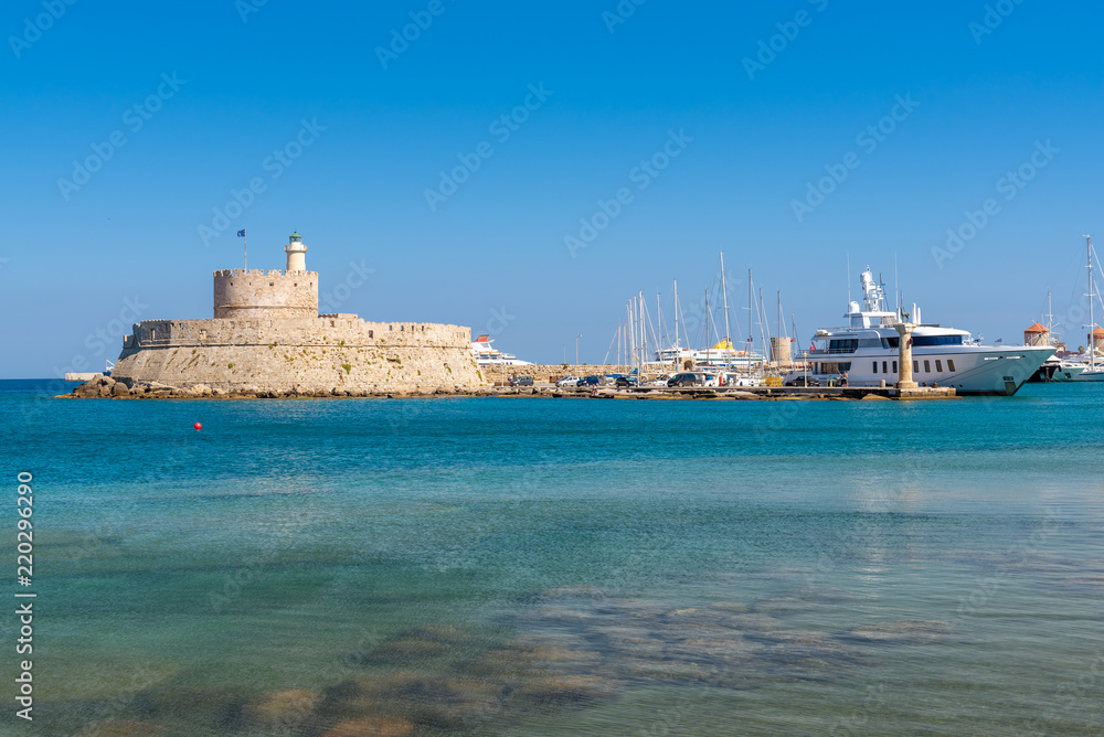 Mandraki harbor and Fort of St. Nicholas with lighthouse in Rhodes island.