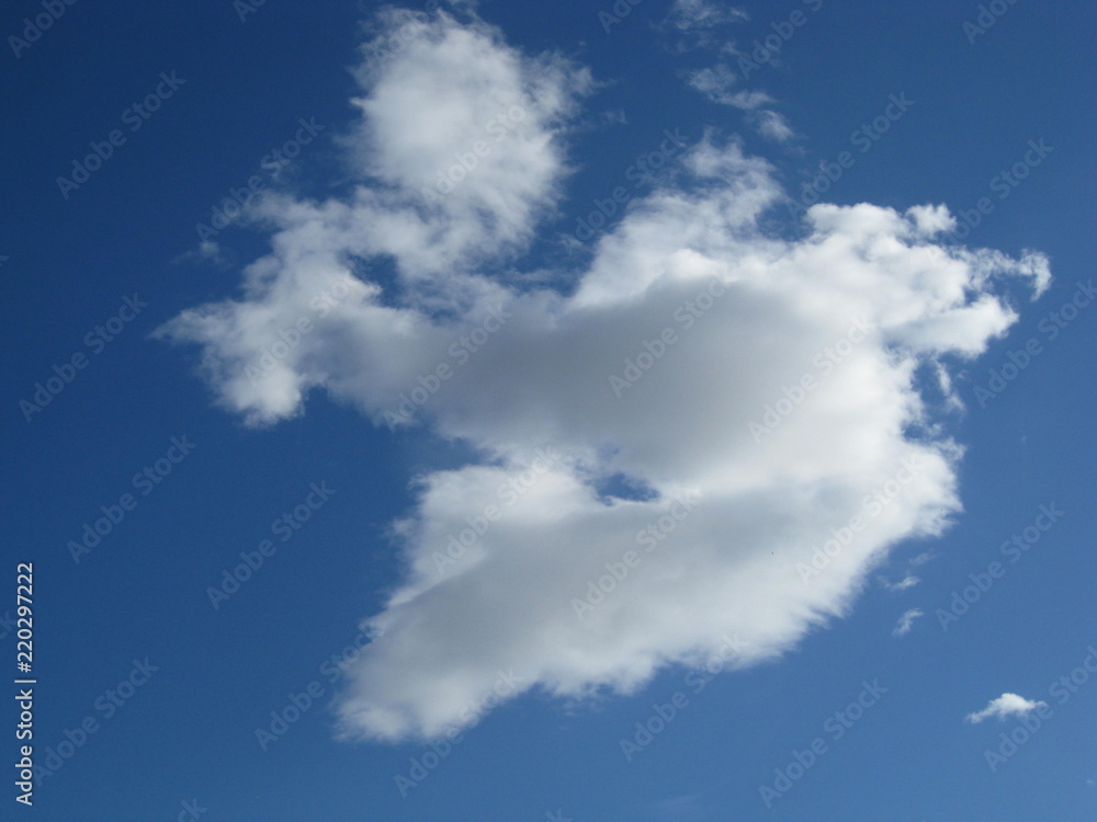 Nube blanca y gris en forma de corazón roto, aislada en cielo azul Nube blanca y gris en forma de corazón roto, aislada en cielo azul