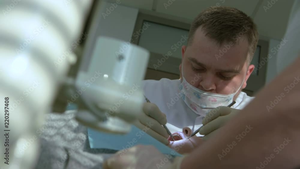 Male Dentist Is Fixing Teeth Of Female Patient Male Dentist Is Fixing Teeth Of Female Patient