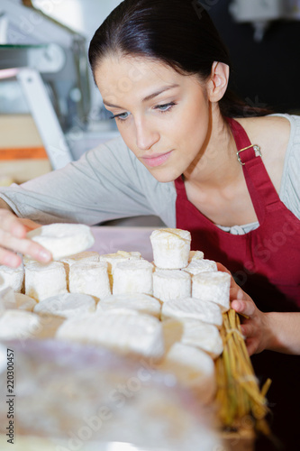 cheerful young shopgirl selling cheese photo