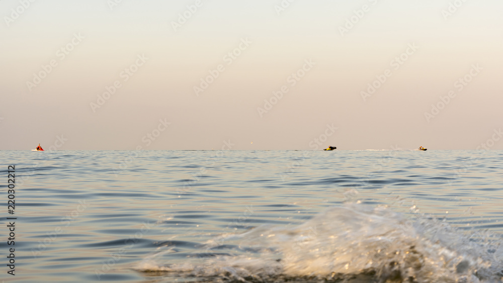 Fototapeta premium evening sea with waves, far away on a horizon line floating ship, nature abstract background