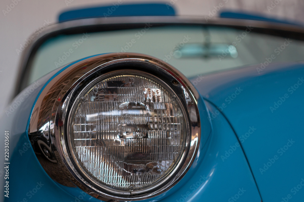 The headlight of an old, rarity, vintage blue car.