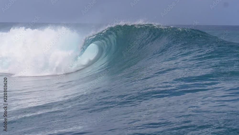 SLOW MOTION, CLOSE UP: Powerful deep blue swell coming from the Pacific Ocean crashes near the shore of a remote exotic island. Breathtaking crystal clear tube wave sprays glassy water high in the sky SLOW MOTION, CLOSE UP: Powerful deep blue swell coming from the Pacific Ocean crashes near the shore of a remote exotic island. Breathtaking crystal clear tube wave sprays glassy water high in the sky