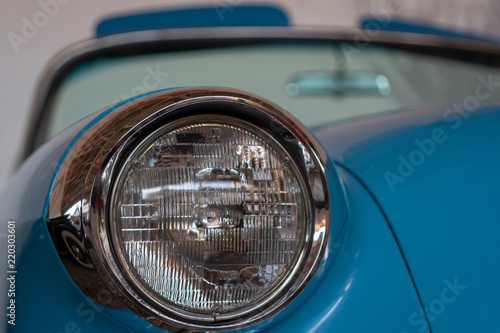 The headlight of an old, rarity, vintage blue car.