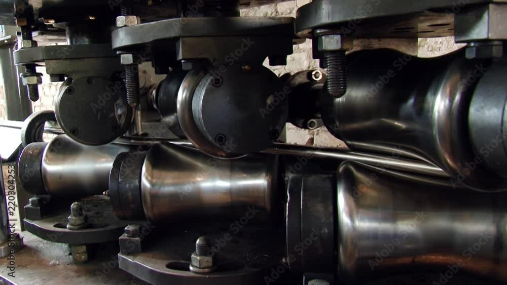 Close-up of metal-rolling machines for production metal steel pipes in factory. Seamless technology for production of profile pipe. Close-up of metal-rolling machines for production metal steel pipes in factory. Seamless technology for production of profile pipe.