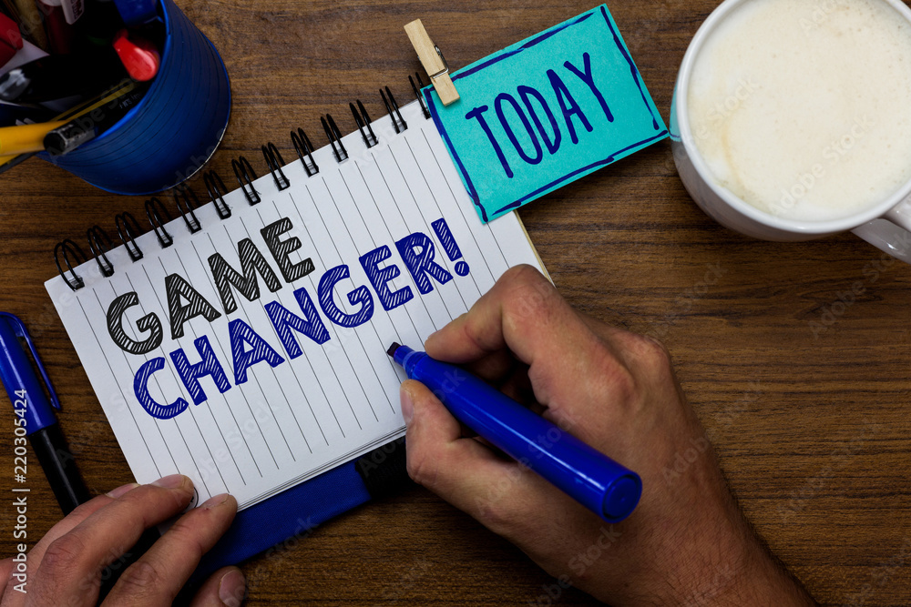 Text sign showing Game Changer. Conceptual photo Sports Data Scorekeeper Gamestreams Live Scores Team Admins Man holding marker notebook clothespin reminder wooden table cup coffee Text sign showing Game Changer. Conceptual photo Sports Data Scorekeeper Gamestreams Live Scores Team Admins Man holding marker notebook clothespin reminder wooden table cup coffee