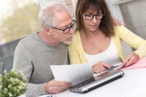 Senior couple checking financial document