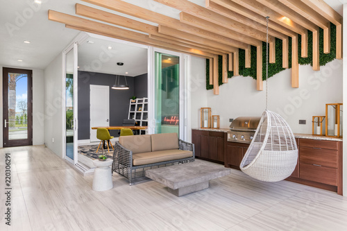 modern covered porch and outdoor area with hanging wicker chair